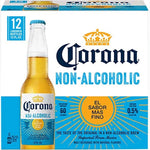 A 12-pack box of Corona Non-Alcoholic malt beverage, featuring a large image of a single bottle with a condered cap on the front, set against a white and blue background with yellow sunburst graphics.