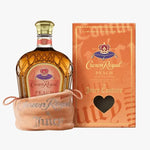 Crown Royal Peach by Juicy Couture liquor bottle displayed next to its orange packaging box and a peach drawstring pouch on a white background.