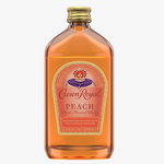 A bottle of Crown Royal Peach Blended and Infused Whiskey on a solid white background. The bottle is made of transparent amber glass showing the orange liquid inside, with a gold screw cap and a prominent peach-colored label featuring the red and gold Crown Royal logo.