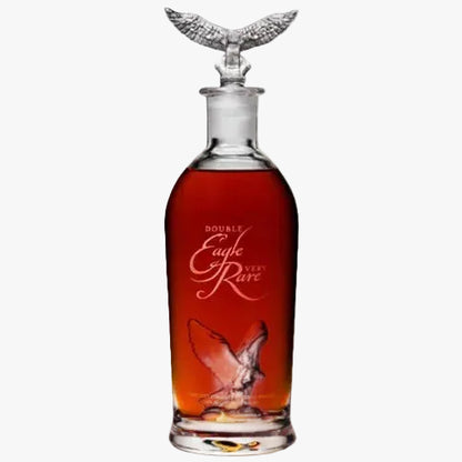 A clear glass decanter filled with amber liquor, featuring a sculpted silver eagle perched on the shoulders of the bottle and etched text reading 'Double Eagle Rare' on the front, set against a plain white background.