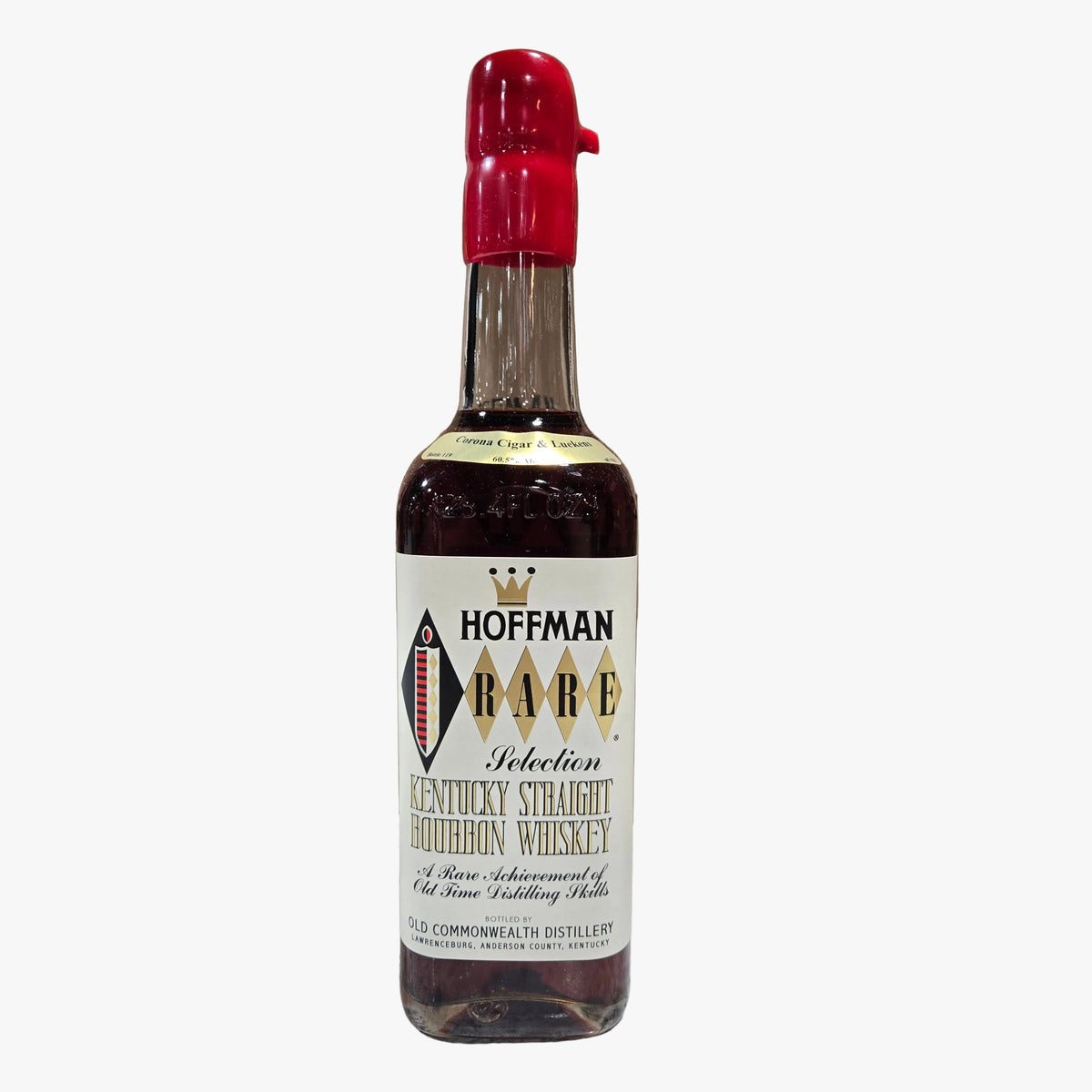 A bottle of Hoffman Rare Kentucky Straight Bourbon Whiskey stands in front of its open cardboard box on a marble countertop, with a blurred liquor store shelf background.