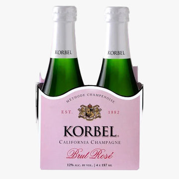 A 4-pack of Korbel Brut Rosé California Champagne bottles in a pink cardboard carrier. The green glass bottles have white neck foils with the Korbel logo, and the carrier features a light pink label with black and red text.