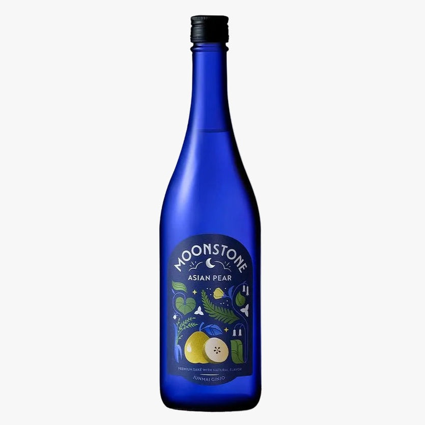 A cobalt blue glass bottle of Moonstone Asian Pear sparkling non-alcoholic beverage, displayed on a rustic wood slice against a textured light gray background.