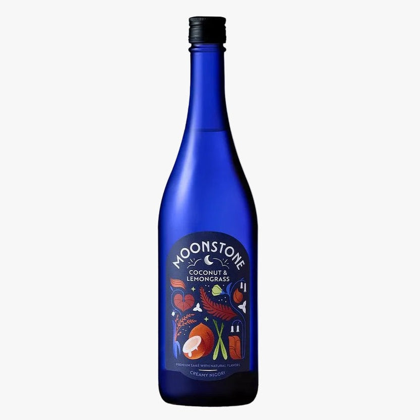 A cobalt blue glass bottle of Moonstone Coconut &amp; Lemongrass Non-Alcoholic Spirit of Wine with a black cap, displayed on a rustic wood slice against a textured light gray background.