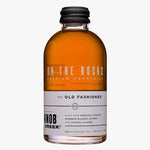 A bottle of Knob Creek On the Rocks Premium Cocktails, 'The Old Fashioned' flavor, featuring amber whiskey in a clear glass bottle with a black cap and a white label.