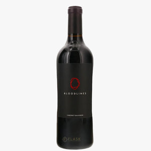 A bottle of Bloodlines Cabernet Sauvignon red wine by the brand Flask, featuring a black label with a red circular logo and white text, set against a plain white background.