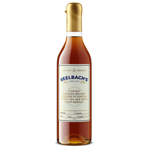 A bottle of Seelbach's Straight Bourbon Whiskey with a gold cap and a cream-colored label, shown against a plain white background.