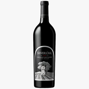 A bottle of Silver Oak Cabernet Sauvignon from Napa Valley, featuring a black bottle and a white label with a detailed illustration of a vineyard and winery.
