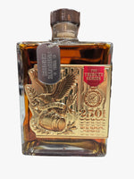 Bourbon whiskey bottle with gold design and 'Tribute Series' label in a store setting