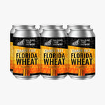 Three aluminum cans of Walking Tree Brewery Sandy Feet Florida Wheat beer arranged side by side on a white background.