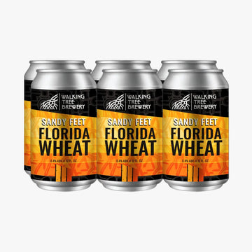 Three aluminum cans of Walking Tree Brewery Sandy Feet Florida Wheat beer arranged side by side on a white background.