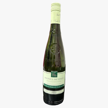 A bottle of Coèle des Rosés D'Anjouvin Cuvrier de Pinet dry wine, standing on a dark tabletop with pink branded boxes stacked in the background on a metal shelf.